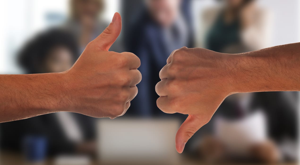 Two hands—one doing thumbs up, one doing thumbs down