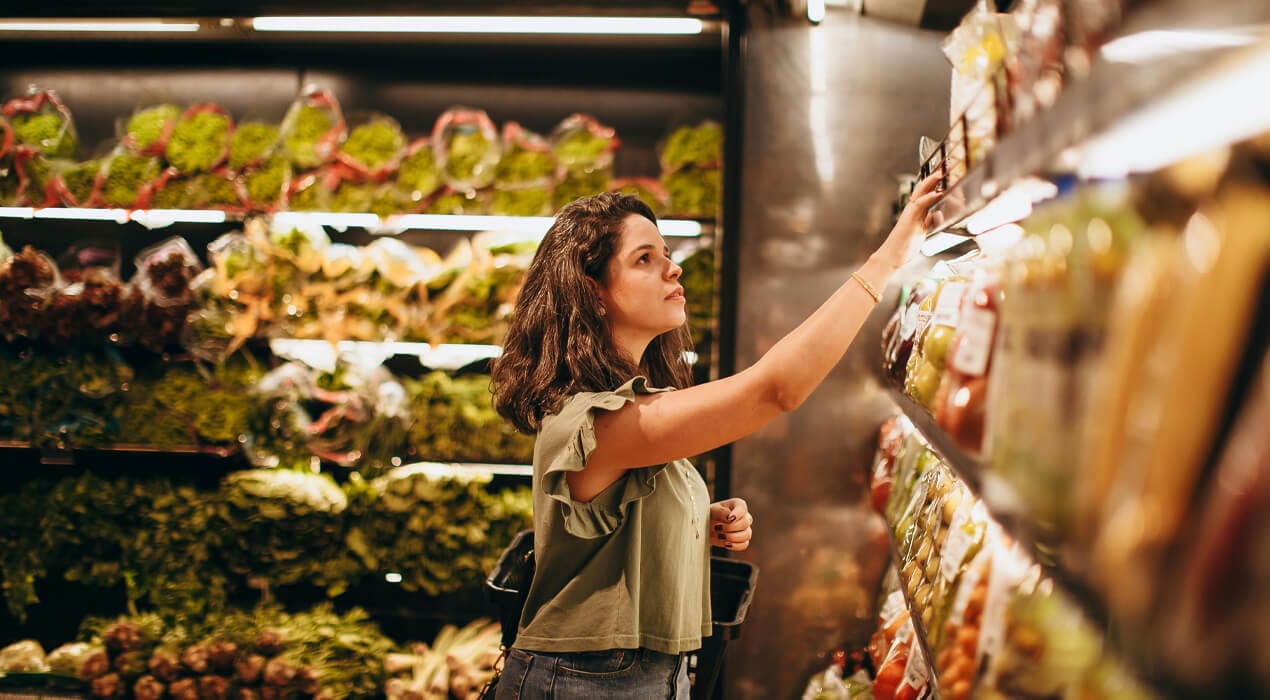 Woman shopping in the vegetable section of a supermarket