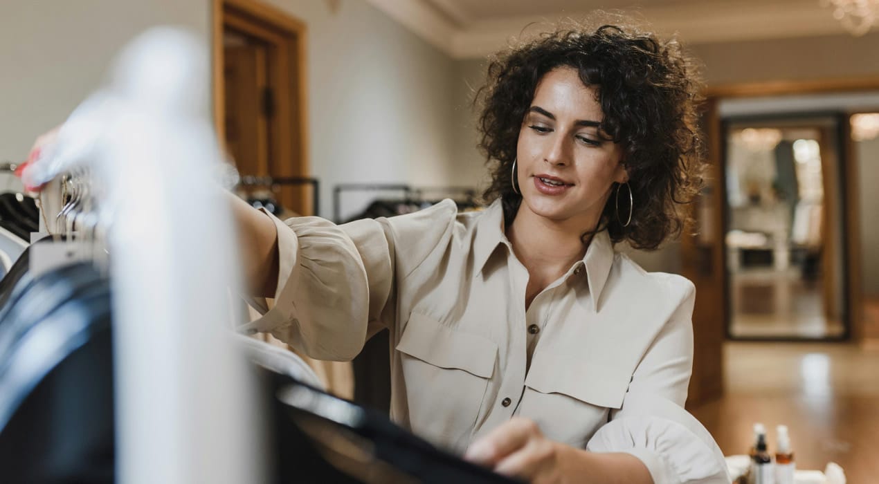 Young woman choosing clothes from a clothes rack