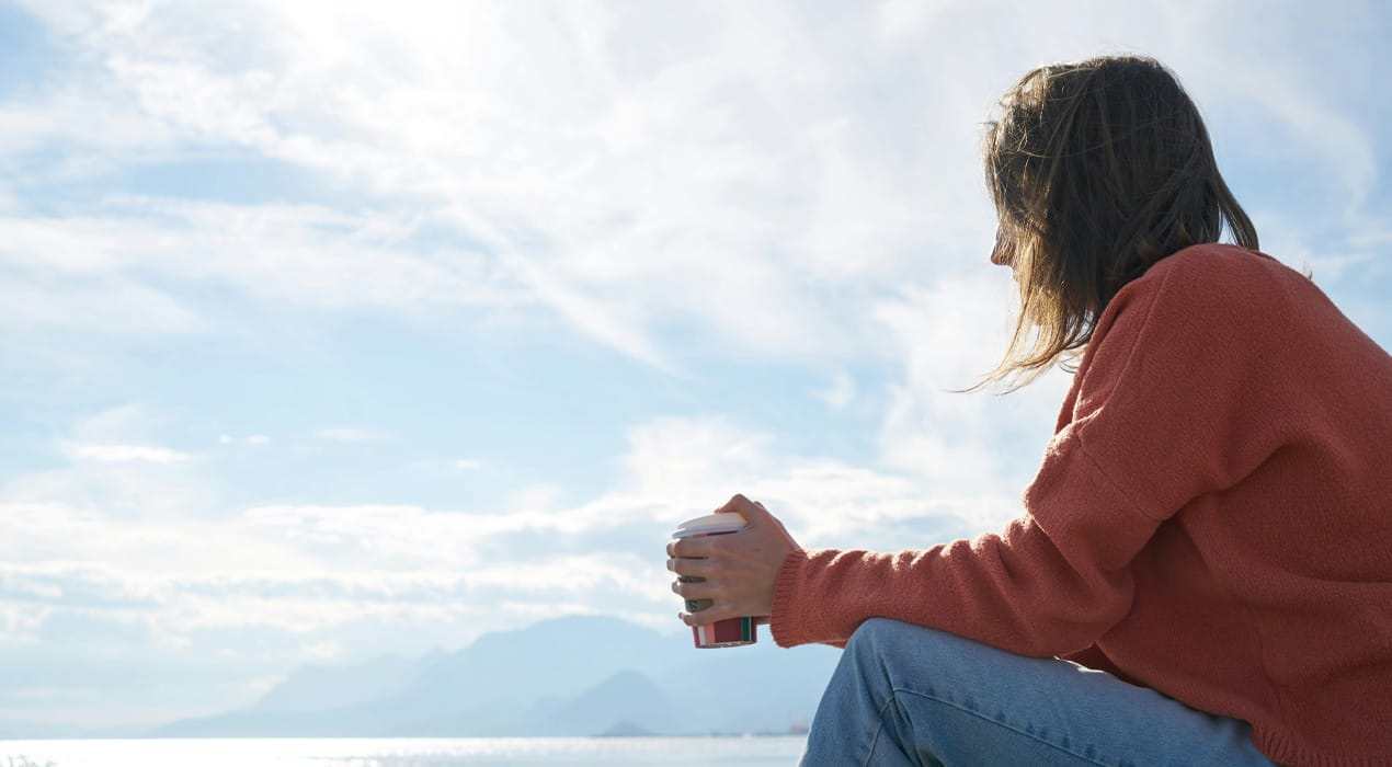 Woman sitting looking out over the ocean
